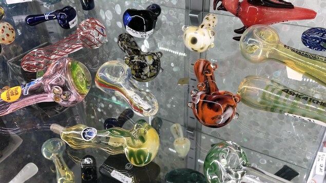 De petites pipes de verre colorées sont déposées sur une tablette. De petites pipes de verre colorées sont déposées sur une tablette.