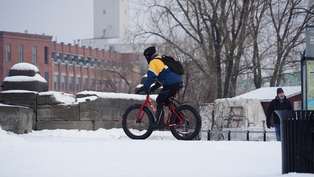 Un homme fait du vélo sur la neige.