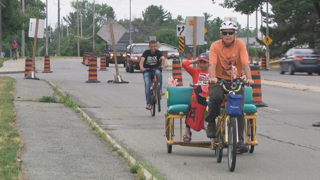 Des cyclistes utilisent une piste cyclable aménagée sur une voie de circulation normalement réservée aux voitures.