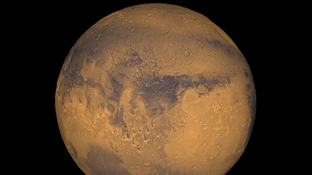 Une sphère, qui est rouge et orange et qui a une multitude de trous, est vue dans un espace tout noir.