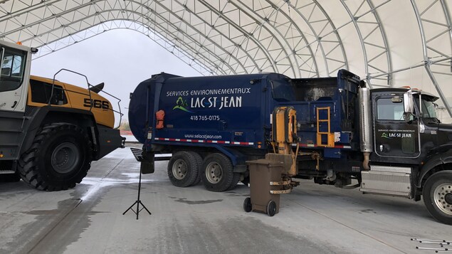 Des camions dans un hangar et un bac brun à côté d'un lutrin