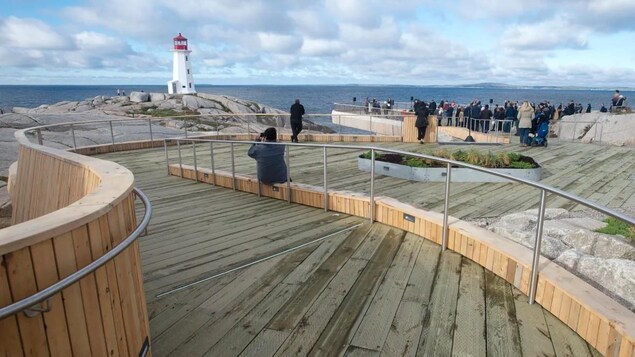 Des gens sur la structure en bois permettant d'accéder au site de Peggy's Cove.