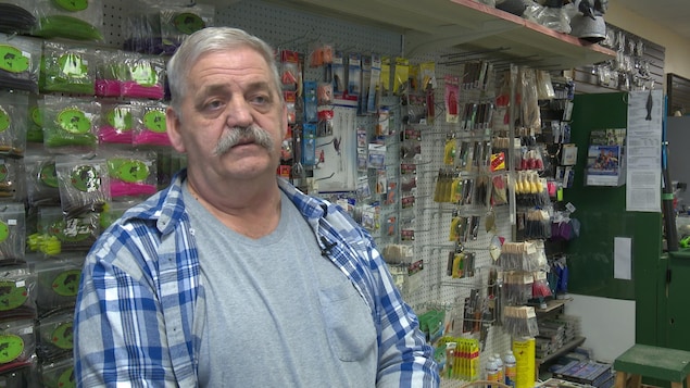 Le propriétaire dans sa boutique avec en arrière plan des articles de pêche. Le propriétaire dans sa boutique avec en arrière plan des articles de pêche.