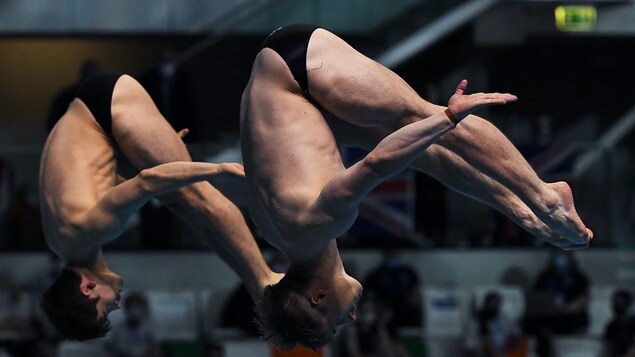 Deux athlètes qui réussi un plongeon synchronisé.