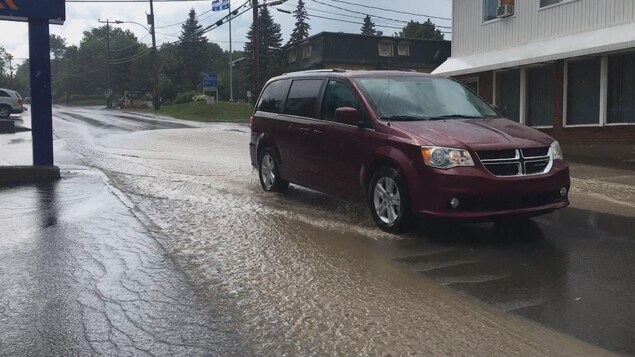 Auto qui roule dans l'eau dans une rue de Gaspé Auto qui roule dans l'eau dans une rue de Gaspé