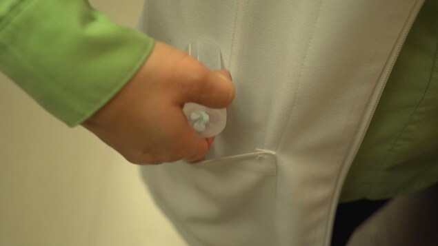 Un professionnel de la santé met des comprimés dans sa poche. Un professionnel de la santé met des comprimés dans sa poche.
