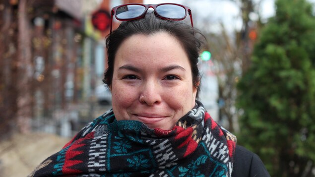 La poète multidisciplinaire innue Natasha Kanapé Fontaine pose dans la rue avec un foulard coloré.