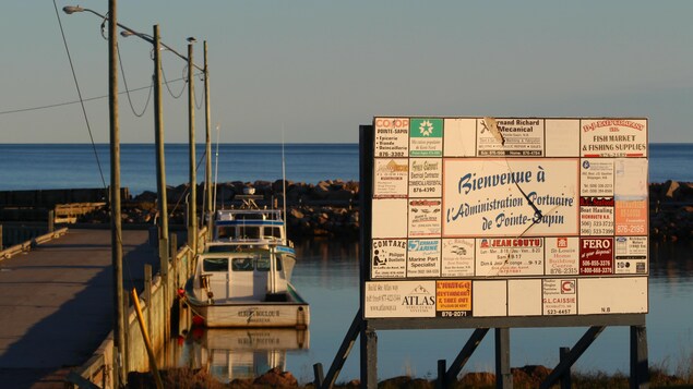L'enseigne de l'administration portuaire de Pointe-Sapin près d'un quai.