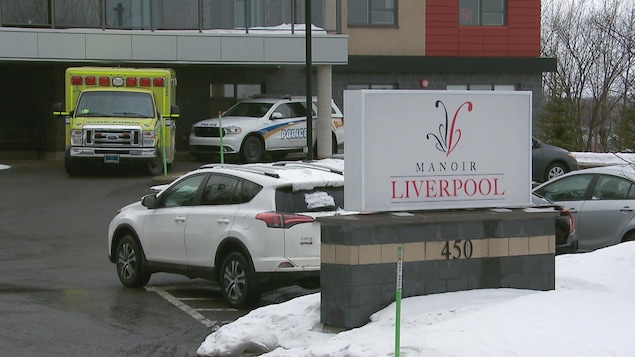 Une ambulance et un véhicule de police devant un immeuble.