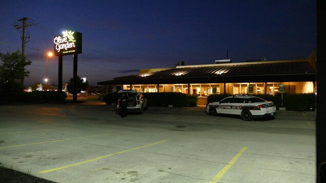 Deux voitures de police devant un restaurant Olive Garden.