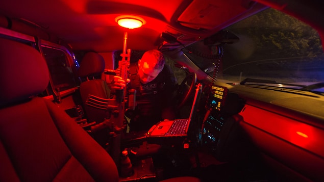 Un agent de la GRC lourdement armé dans une voiture de patrouille en Colombie-Britannique.