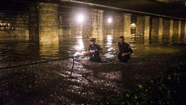 Deux policiers ont de l'eau jusqu'à la taille. Deux policiers ont de l'eau jusqu'à la taille.