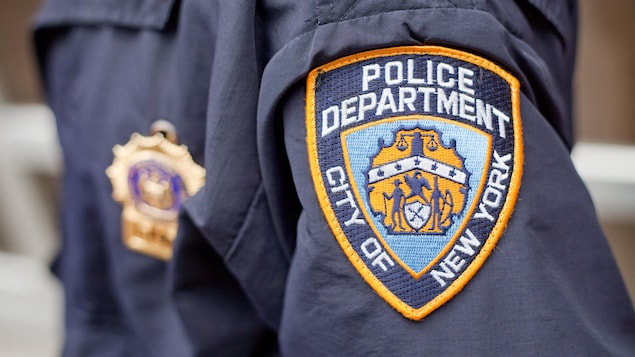 L'écusson de la police de New York sur l'uniforme d'un agent.