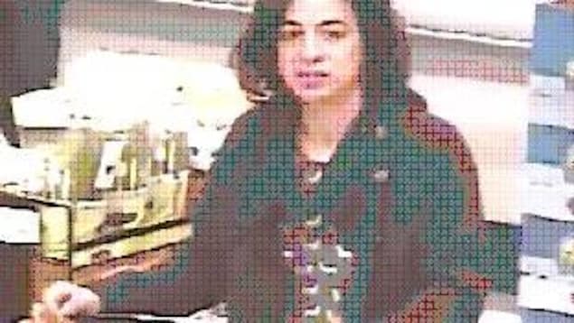 Image tirée d'une caméra de surveillance d'une femme d'âge adulte à la peau claire et aux cheveux brun foncé lui arrivant aux épaules. Elle porte une veste de couleur foncée. Image tirée d'une caméra de surveillance d'une femme d'âge adulte à la peau claire et aux cheveux brun foncé lui arrivant aux épaules. Elle porte une veste de couleur foncée.