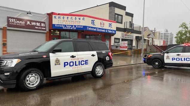 Des voitures de police devant un commerce dans le quartier chinois.
