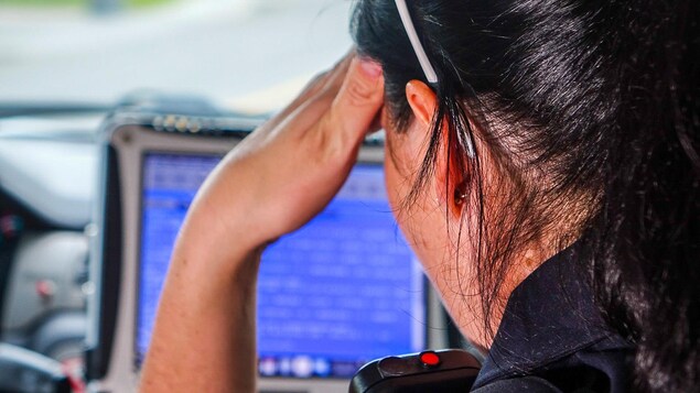 La sergente Julie Marcotte consulte un ordinateur à bord d'une voiture de patrouille du Service de police de la Ville de Québec La sergente Julie Marcotte consulte un ordinateur à bord d'une voiture de patrouille du Service de police de la Ville de Québec