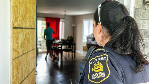 La sergente Julie Marcotte regarde dans un appartement où ses collègues interviennent pour une femme en crise suicidaire La sergente Julie Marcotte regarde dans un appartement où ses collègues interviennent pour une femme en crise suicidaire
