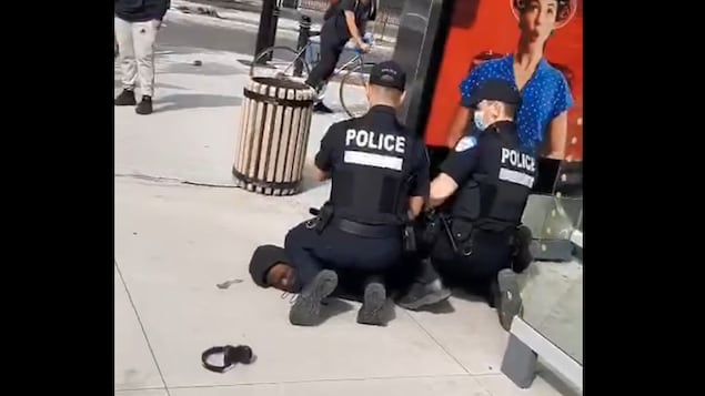 Des policiers mettent un genou sur le cou d'un jeune homme noir.