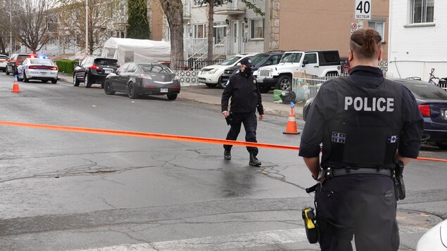 Un périmètre de sécurité érigé dans la rue avec deux policiers du SPVM.