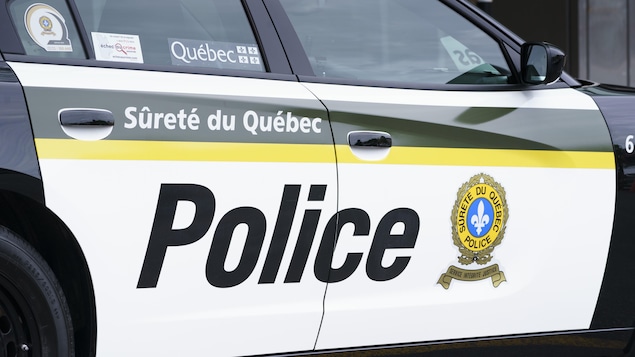 Une voiture de police affichant le logo de la Sûreté du Québec et le mot «Police».