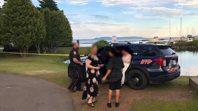 Une mariée prend une photo dans un véhicule de police près d’une possible scène de crime