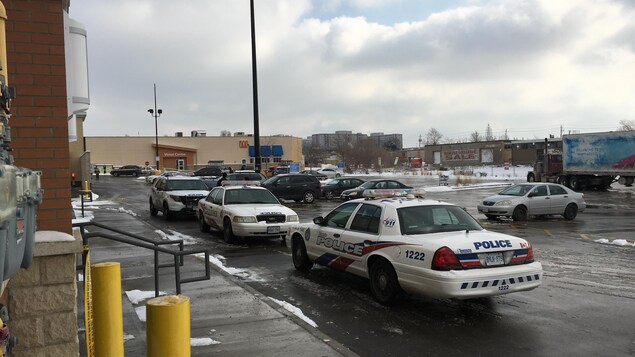 Photo de trois véhicules de police stationnés près d'un magasin à grande surface. Photo de trois véhicules de police stationnés près d'un magasin à grande surface.