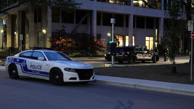 شيّارة شرطة مونتريال متوقّفة أمام مبنىً.