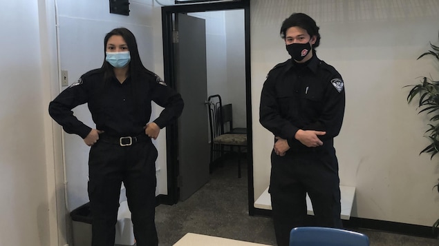 Une jeune femme et un homme autochtones habillés en policiers.