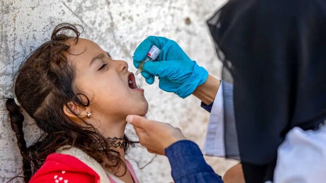 A Yemeni child receives an oral polio vaccination during a home visit by health workers as part of an immunization campaign in February 2022. (Ahmad Al-Basha/AFP/Getty Images)