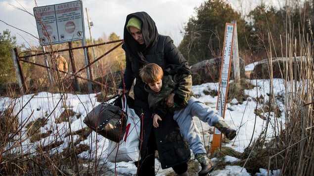 Une photo montre une femme et son enfant traversent la frontière canado-américaine à la hauteur de Hemmingford au Québec.
