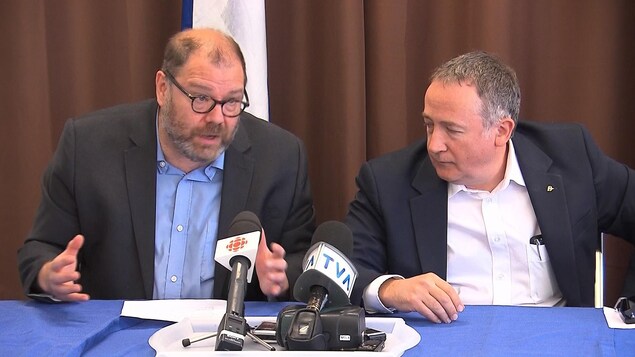 Mario Beaulieu et Yves Perron sont assis à une table, derrière des micros. Mario Beaulieu et Yves Perron sont assis à une table, derrière des micros.