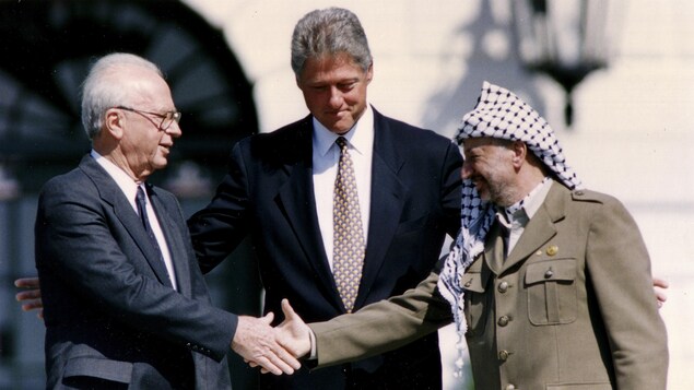 Yasser Arafat serre la main à Yitzhak Rabin devant Bill Clinton, à la Maison-Blanche. Yasser Arafat serre la main à Yitzhak Rabin devant Bill Clinton, à la Maison-Blanche.