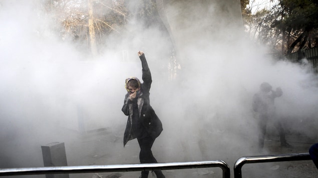 Une manifestante brandit le poing dans un nuage de gaz lacrymogène sur le campus de l'Université de Téhéran. Une manifestante brandit le poing dans un nuage de gaz lacrymogène sur le campus de l'Université de Téhéran.