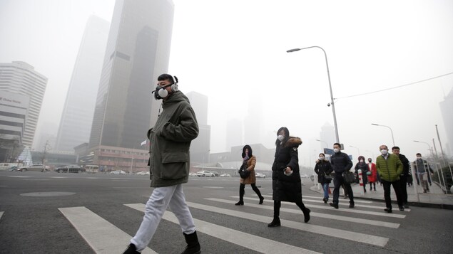 Des passants plongés dans le smog Des passants plongés dans le smog