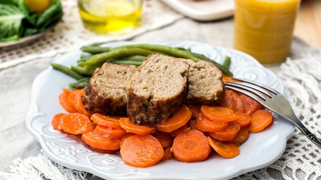 Une assiette de polpettone avec des carottes, des haricots verts et de la sauce Une assiette de polpettone avec des carottes, des haricots verts et de la sauce