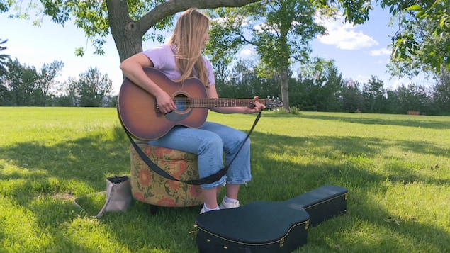 Olivia Vincent joue de la guitare dans un parc à Edmonton. 