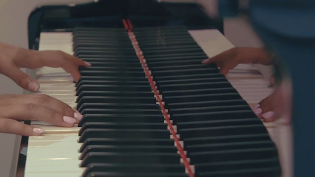 Mains de Nadia Sylvain sur son piano.