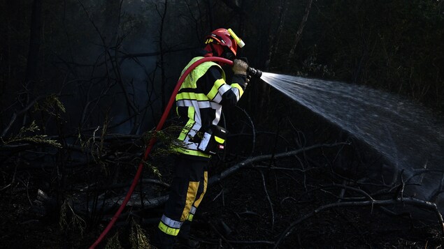 Un pompier est à l'œuvre pour éteindre un incendie.