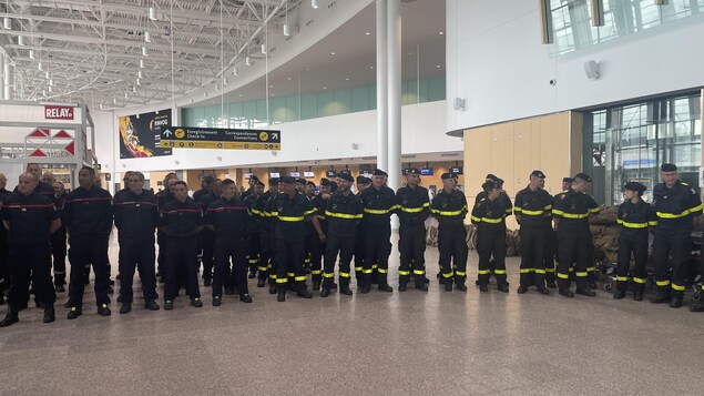 Des dizaines de pompiers dans le hall de l'aéroport.