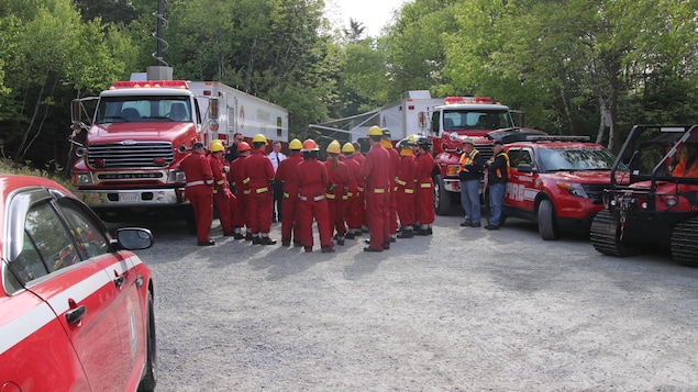 Groupe de pompiers écoutant leur chef, à côté d'un camion d'incendie. Groupe de pompiers écoutant leur chef, à côté d'un camion d'incendie.