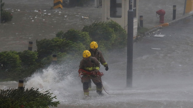 Des pompiers interviennent alors que de hautes vagues déferlent sur les rives de Heng Fa Chien, un quartier résidentiel de Hong Kong.