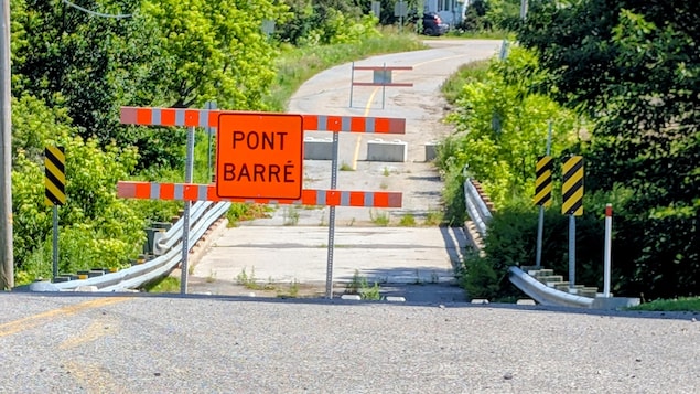 Une pancarte de pont barré devant un ponceau bloqué.