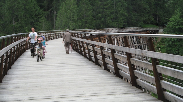 Des enfants sur des bicylettes et deux hommes adultes Des enfants sur des bicylettes et deux hommes adultes