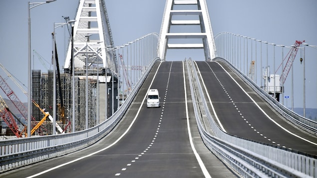 Un véhicule blanc circule sur le pont relie la Russie à la Crimée. Un véhicule blanc circule sur le pont relie la Russie à la Crimée.