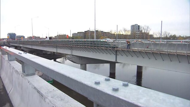 Un ouvrier travaille à poser les derniers éléments du pont. Un ouvrier travaille à poser les derniers éléments du pont.