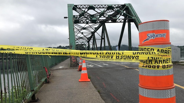 Un cône devant un pont vert.