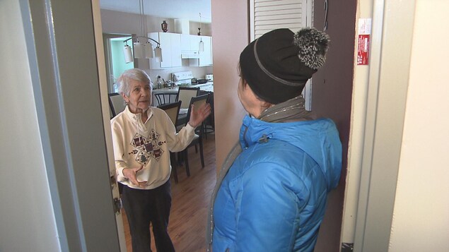 Une bénévole du réseau panquébécois des popotes roulantes rencontre une bénéficiaire.