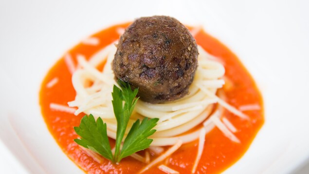 Une boulette de viande cultivée en laboratoire posée sur des pâtes et disposée au centre d'une assiette. Une boulette de viande cultivée en laboratoire posée sur des pâtes et disposée au centre d'une assiette.