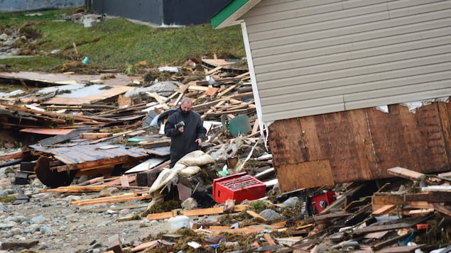 Un homme au milieu des débris d'une maison après le passage de la tempête Fiona à Channel-Port aux Basques, à Terre-Neuve.