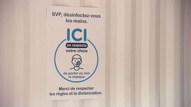 Une affiche indique aux clients qu'ils ont le choix de porter ou non le masque.